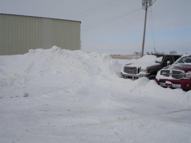 large pile of snow next to building after plowing