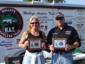 two people holding fishing trophies