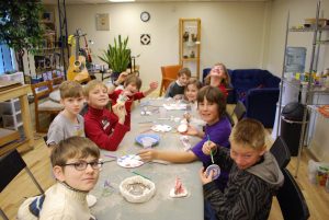 Kids working on art projects at a long table