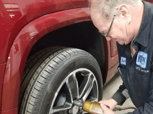 mechanic taking off a wheel after checking the tire pressure