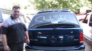 Al standing beside a clunker vehicle