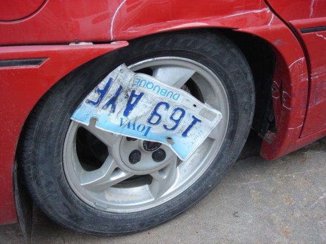 car's license plate caught in the wheel after an accident