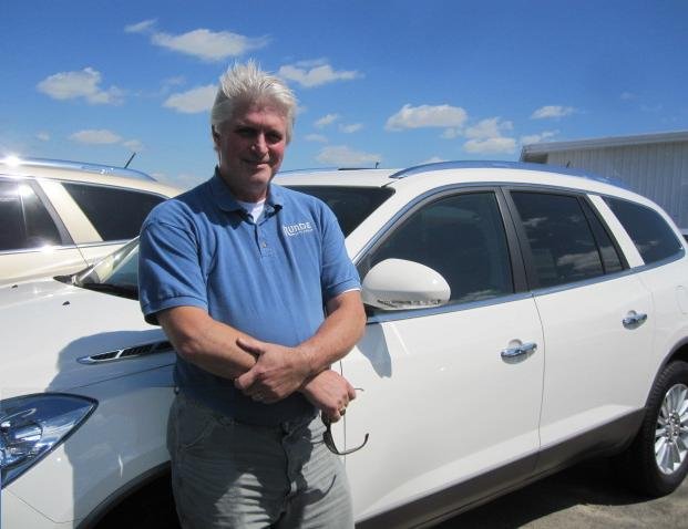 Al Dellabella standing next to a Buick Enclave