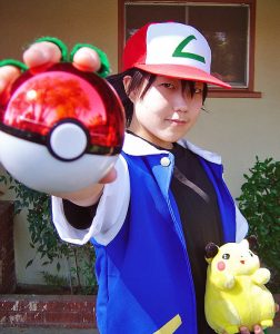 kid dressed like Ash Ketchum holding a pokeball