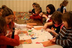 children making Christmas crafts at a table inside St. Marks