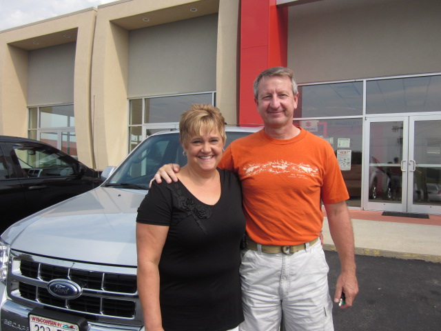 Terry and Teresa Pluemer standing together in front of their new vehicle from Runde's