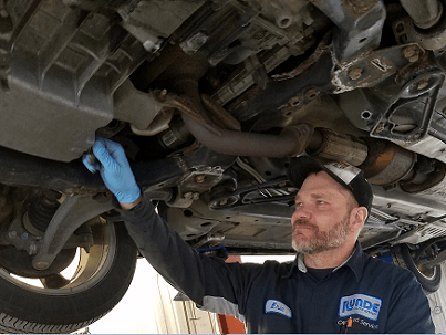 Dubuque area technician performing vehicle maintenance underneath a truck