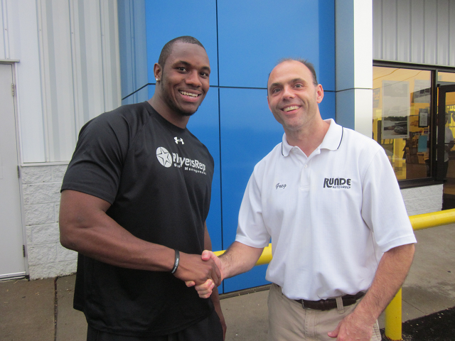 Greg Runde shaking hands with Darius Fleming