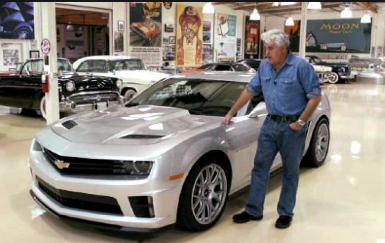 Jay Leno beside his silver Camaro z28