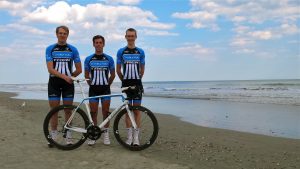 bike team members posing for a photo on a beach