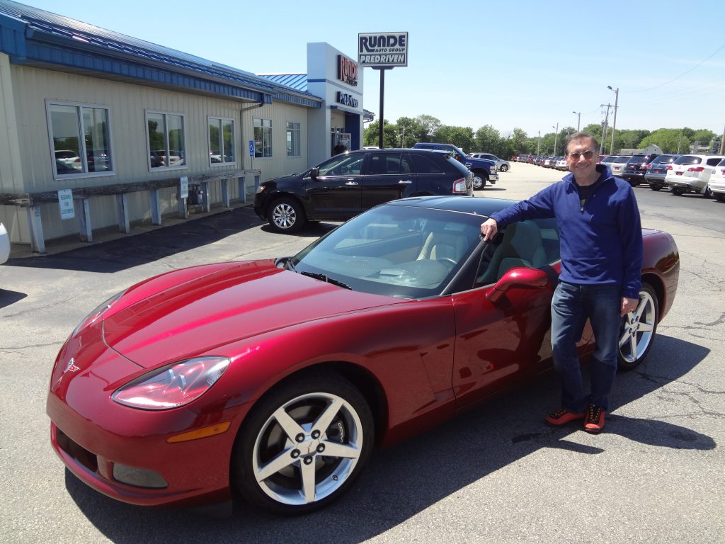 Runde Auto Group customer standing beside his used Corvette