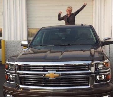 Kelly standing in the bed of her new Chevrolet High Country truck