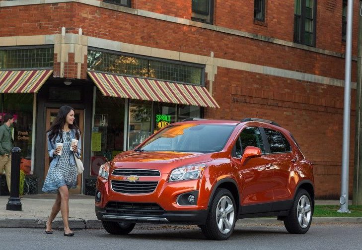 lady walking in front of a new Chevy Trax near Dubuque on a city street