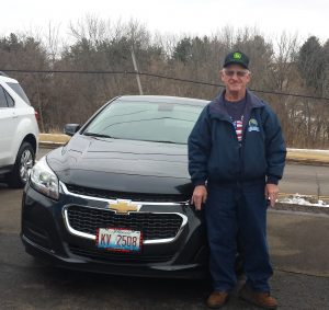 Roland Korte standing in front of his new Chevy Malibu