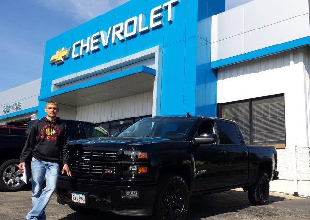 Jake Voss standing in front of his black Midnight Edition Silverado