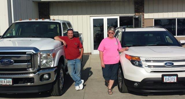 Kenny and Christine Jons standing beside their new Ford truck and new Ford Explorer