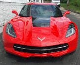 red Corvette parked in front of Chevy dealer serving Galena