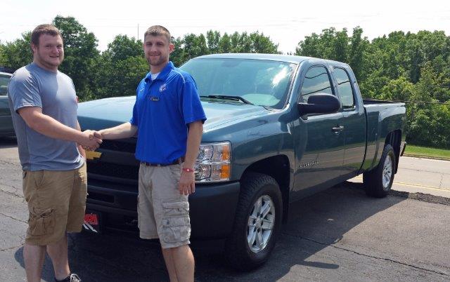 Zach High standing with Jacob Puls in front of his 2010 Chevy Silverado