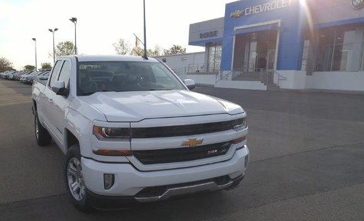 white 2016 Chevrolet Silverado parked in front of Runde Chevrolet showroom