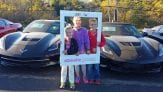 three kids in front of two Corvettes