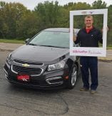 customer standing beside a black Chevy Cruze