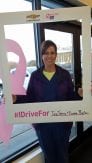 customer holding a sign for the Making Strides Against Breast Cancer campaign