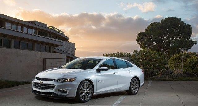 silver new Chevy Malibu sedan shown at sunset