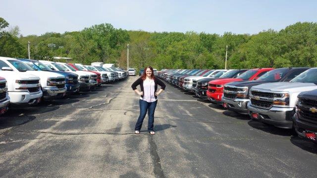 Hannah Rupp posing with new vehicles at Runde Chevrolet