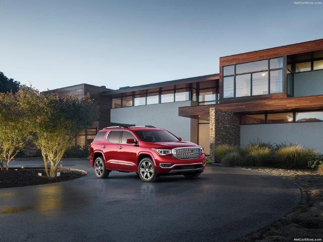 new red GMC Acadia parked in front of a Frank Lloyd Wright styled house