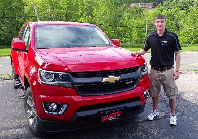 Jacob Puls standing beside a red Chevy Colorado truck