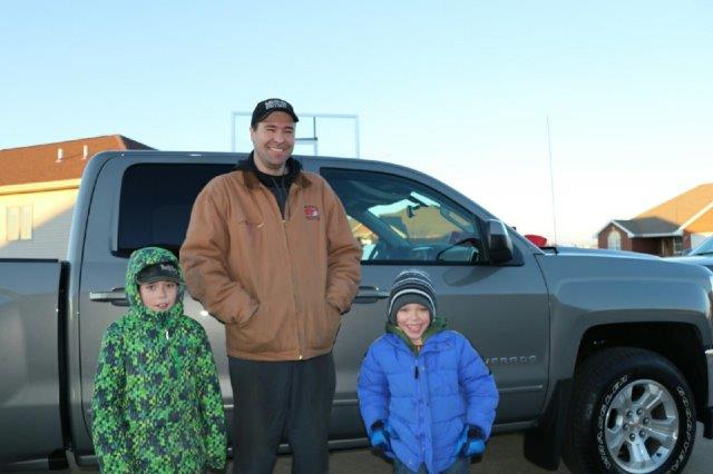 Carloyn's husband and sons in front of the new 2017 Silverado