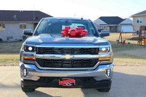 Carolyn's husband's new truck with a red bow on the hood