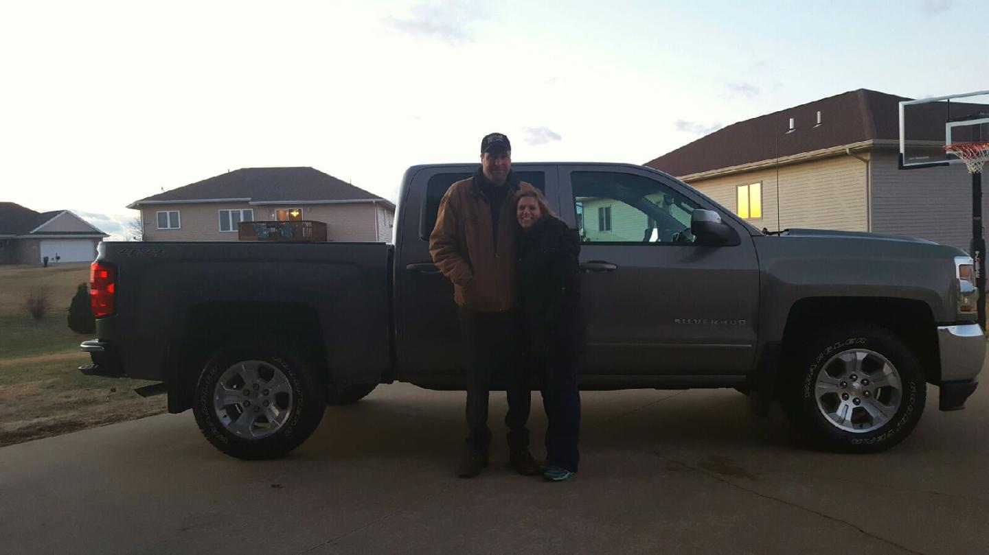 Carolyn and her husband in front of their new truck