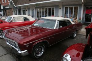 red classic car with white vinyl top