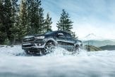 black Ford Ranger pickup driving through snow