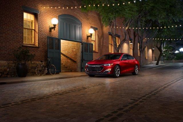 red Chevrolet Malibu parked on a dark street