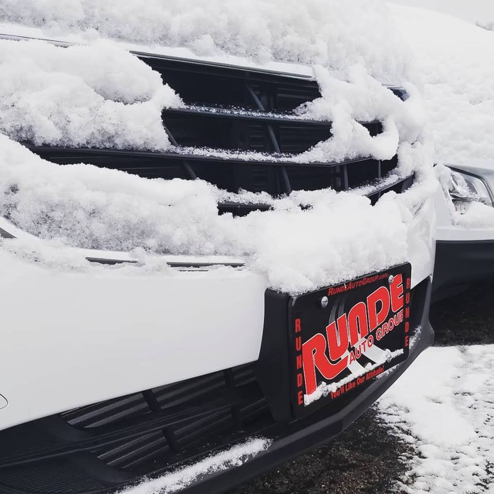 front grill of a Chevrolet Traverse mostly covered with snow