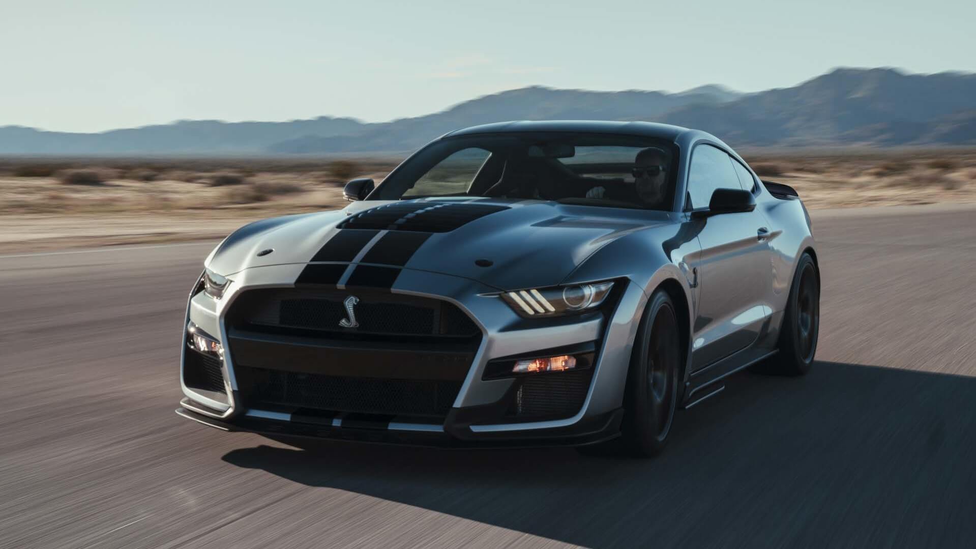 2020 Shelby GT500 driving on a desolate road in front of a mountain range