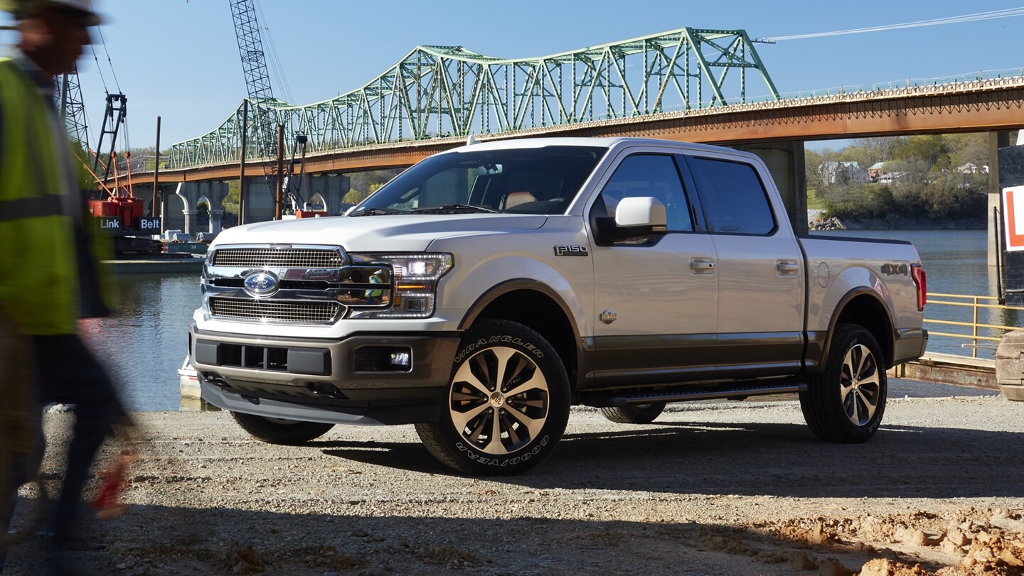 silver Ford full-size truck parked next to a bridge