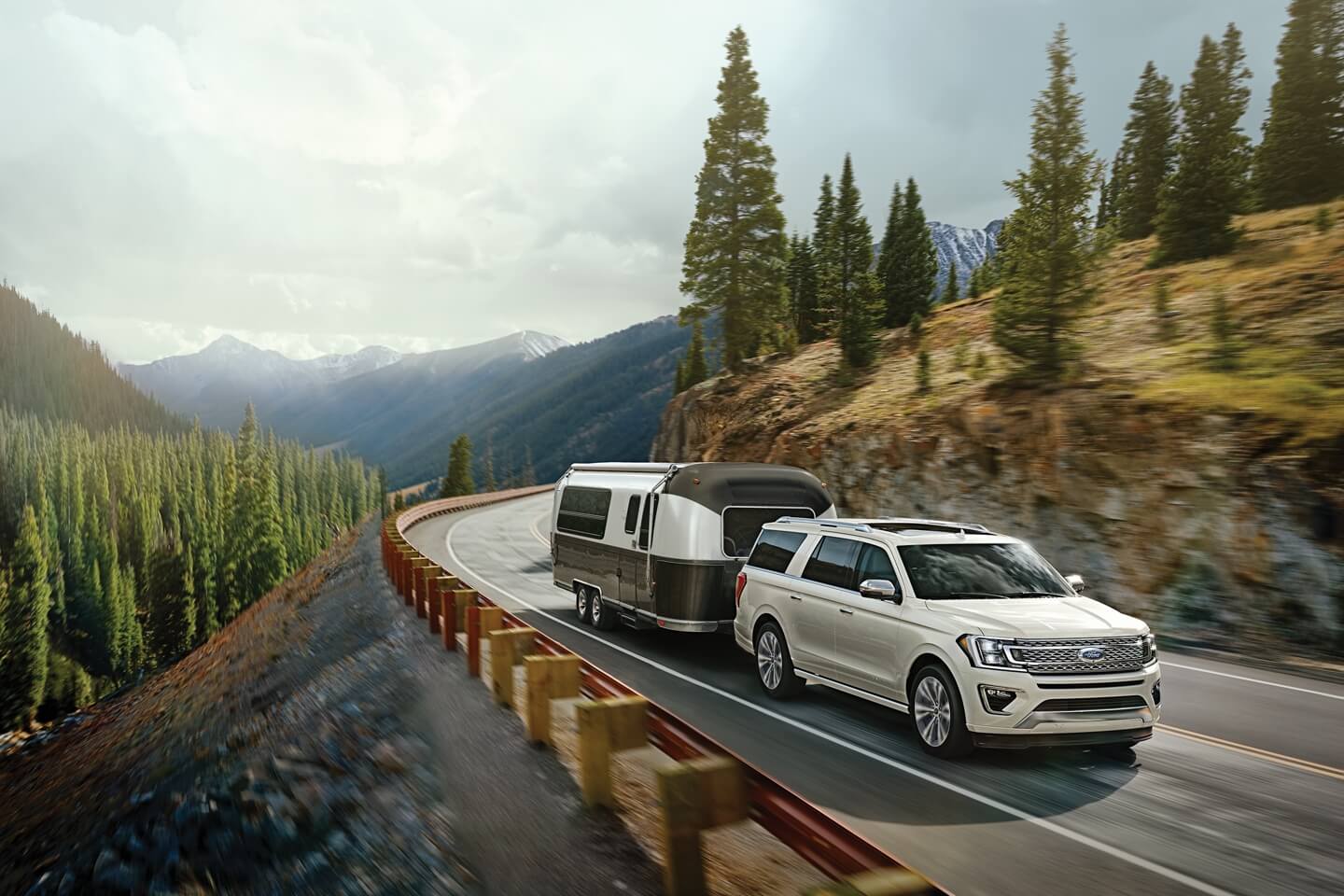 white Ford Expedition towing RV in a mountainous region