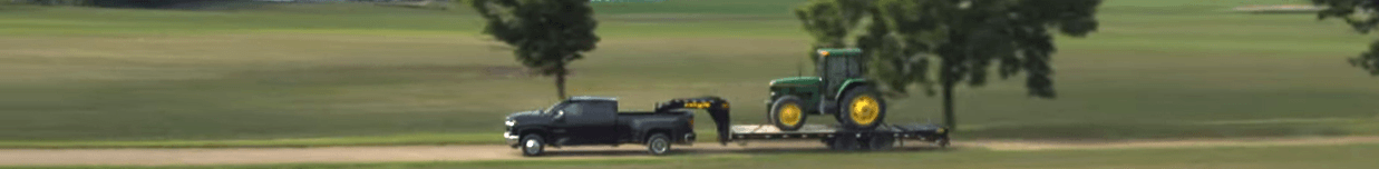 diesel truck hauling a tractor on a flatbed trailer