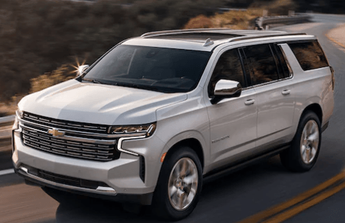 silver new Chevy Suburban driving on the highway