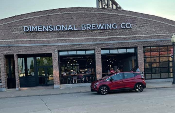 Jesse's electric vehicle parked out in front of Dimensional Brewing Company