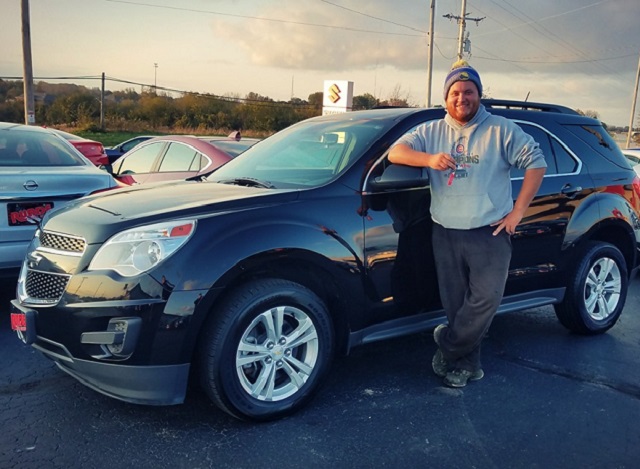 Zach S. from Scales Mound, Illinois strikes a classic pose in front of his 2013 Chevy Equinox that he picked up from Runde PreDriven last week.